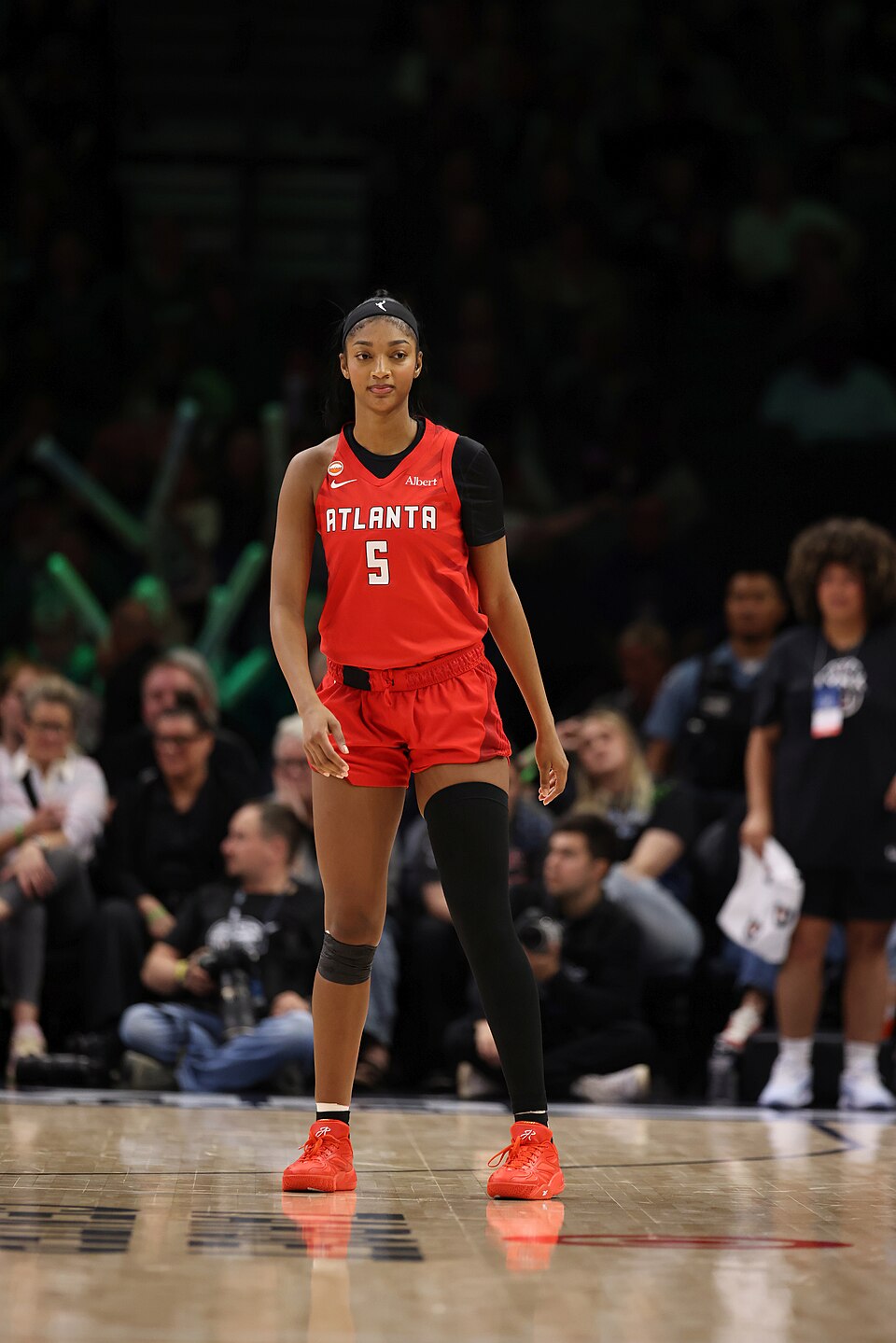 Angel Reese on the court in a red Atlanta Dream number 5 uniform.